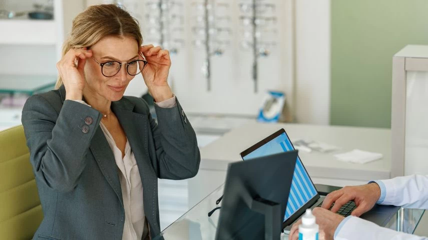 Žena isprobava okvire u optici.