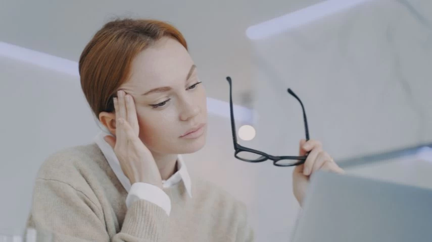 Devojka se drži za glavu dok se privikava na nošenje naočara za vid.